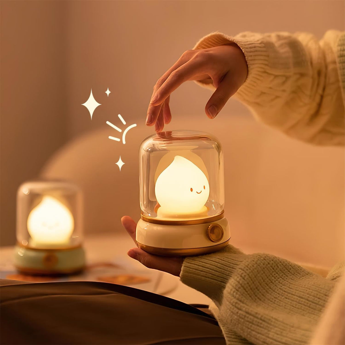 One night light held in a hand beside a second one resting on a book