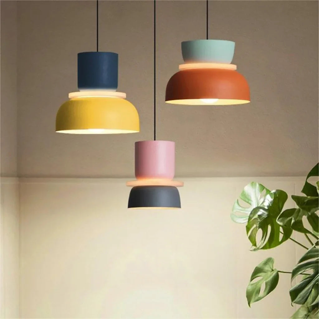 Three lit pendant lights against a warm tan wall