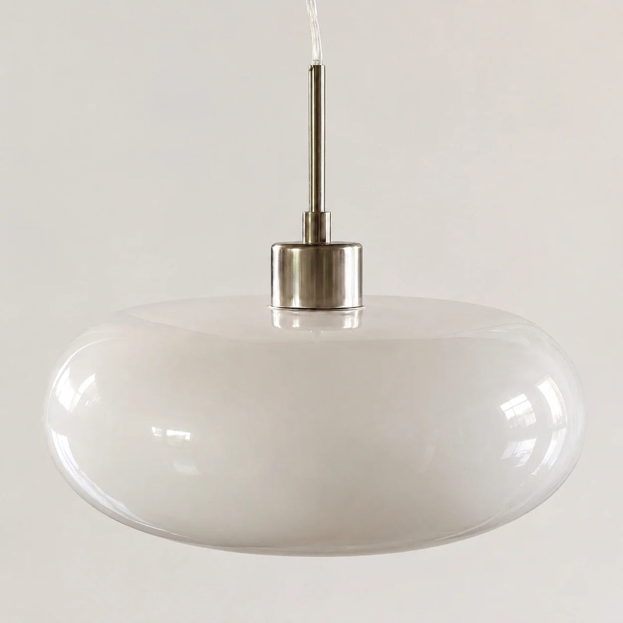 Orange oval glass pendant shade shown against a plain studio background