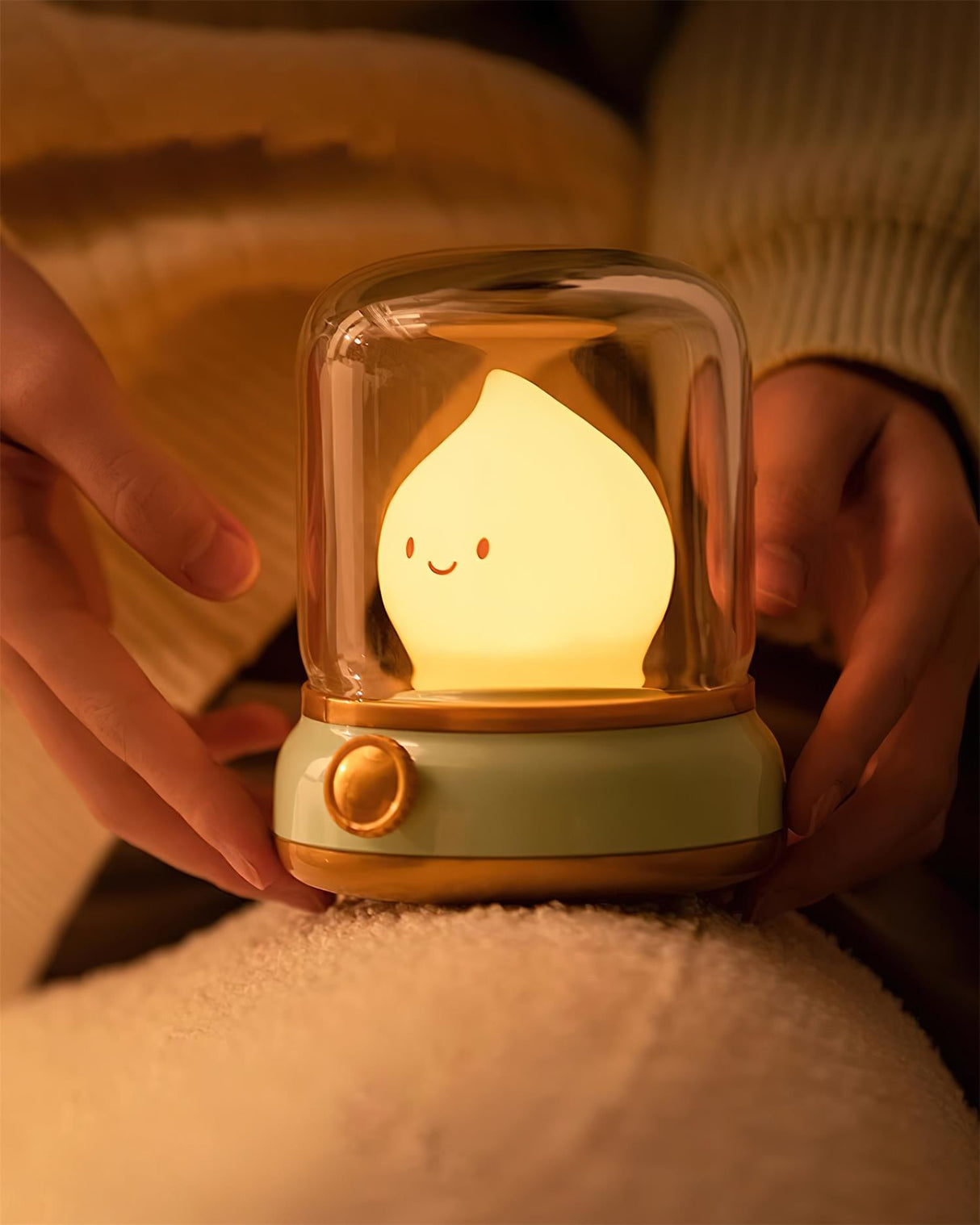 Hand lifting the lit night light from the top of a soft cream blanket