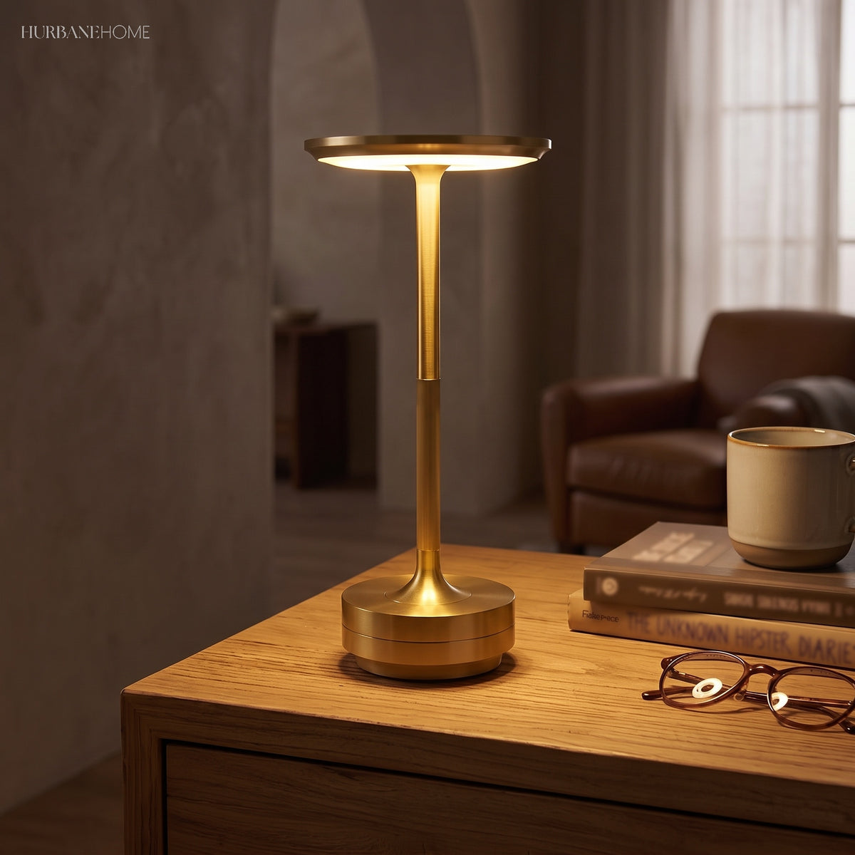 Brass dish table lamp lit on a wooden desk beside a chair