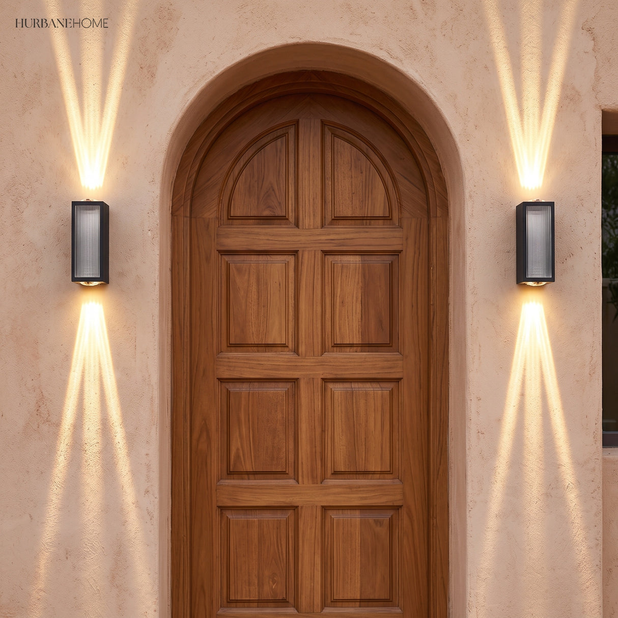 Pair of up and down wall lights flanking an arched wooden door on tan plaster