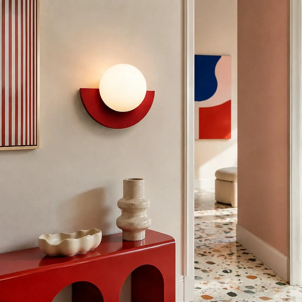 Red glass globe wall sconce against a plain studio background