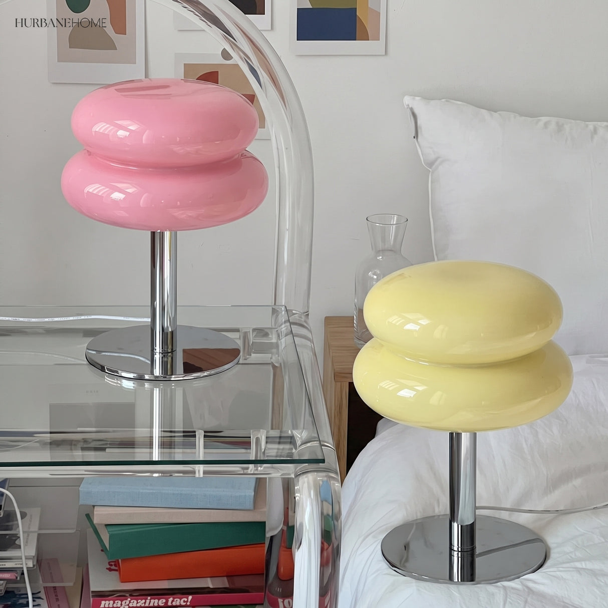 Pink and yellow glass table lamps on a bedside shelf beside a bed