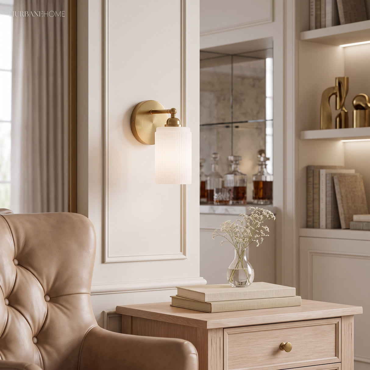 Ribbed glass sconce in a cream panelled room beside a tufted armchair