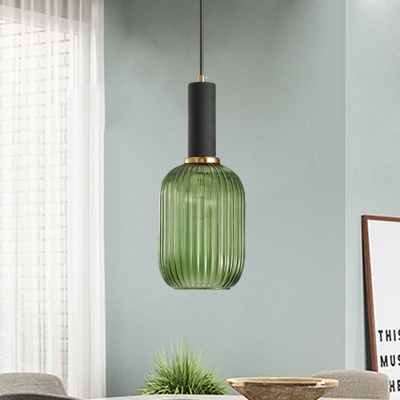 Green ribbed pendant lit by a window on a pale green wall