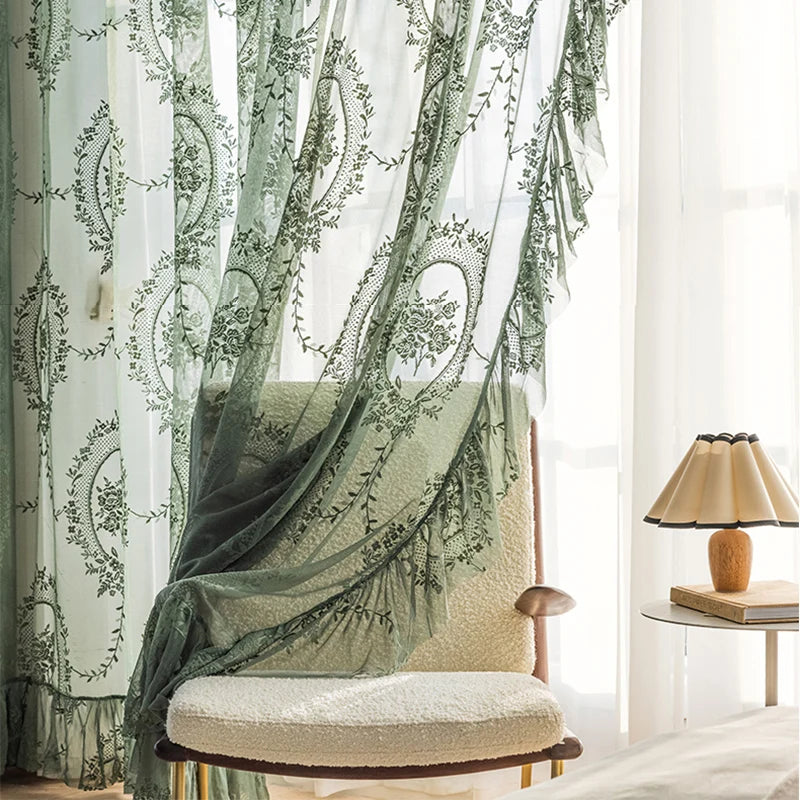 Rod-pocket top design for easy installation of dark green floral embroidered sheer curtains with ruffle detail.