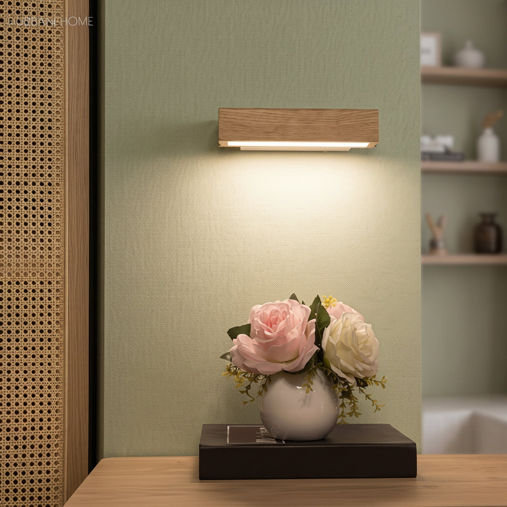Pale oak sconce glowing above a console table with pink roses