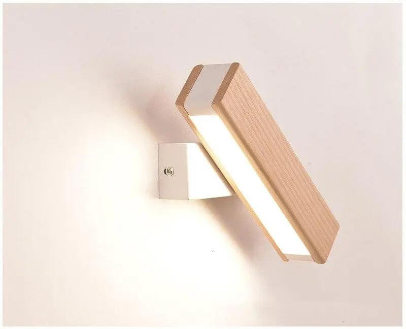 Oak bar sconce tilted downward on a plain white wall
