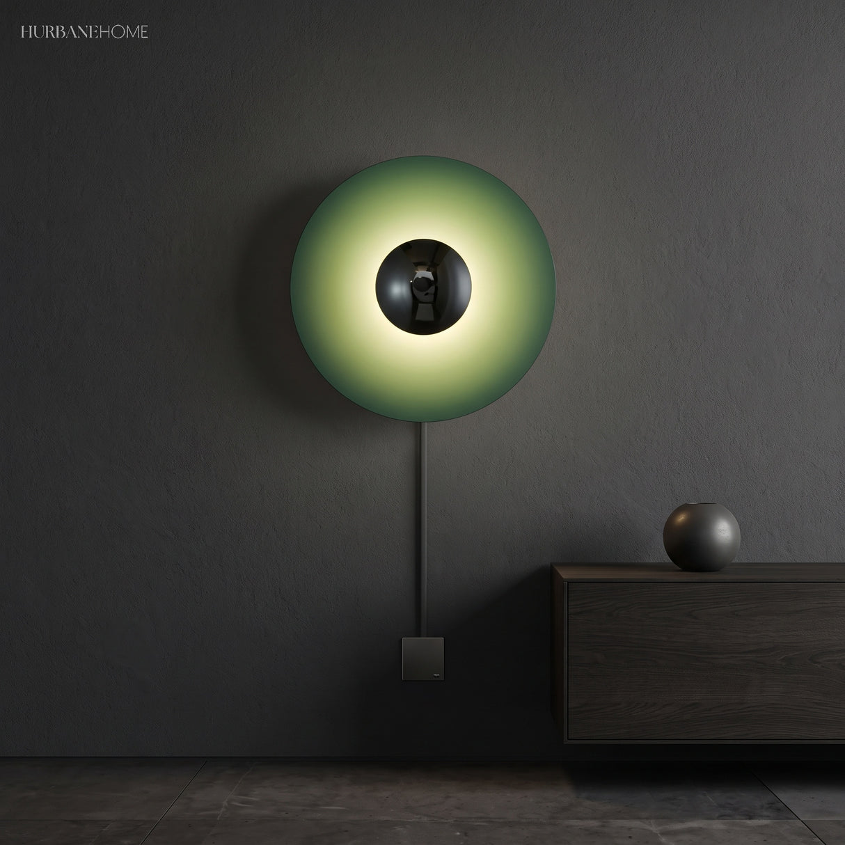 Green disc sconce with a chrome centre lit on a dark wall