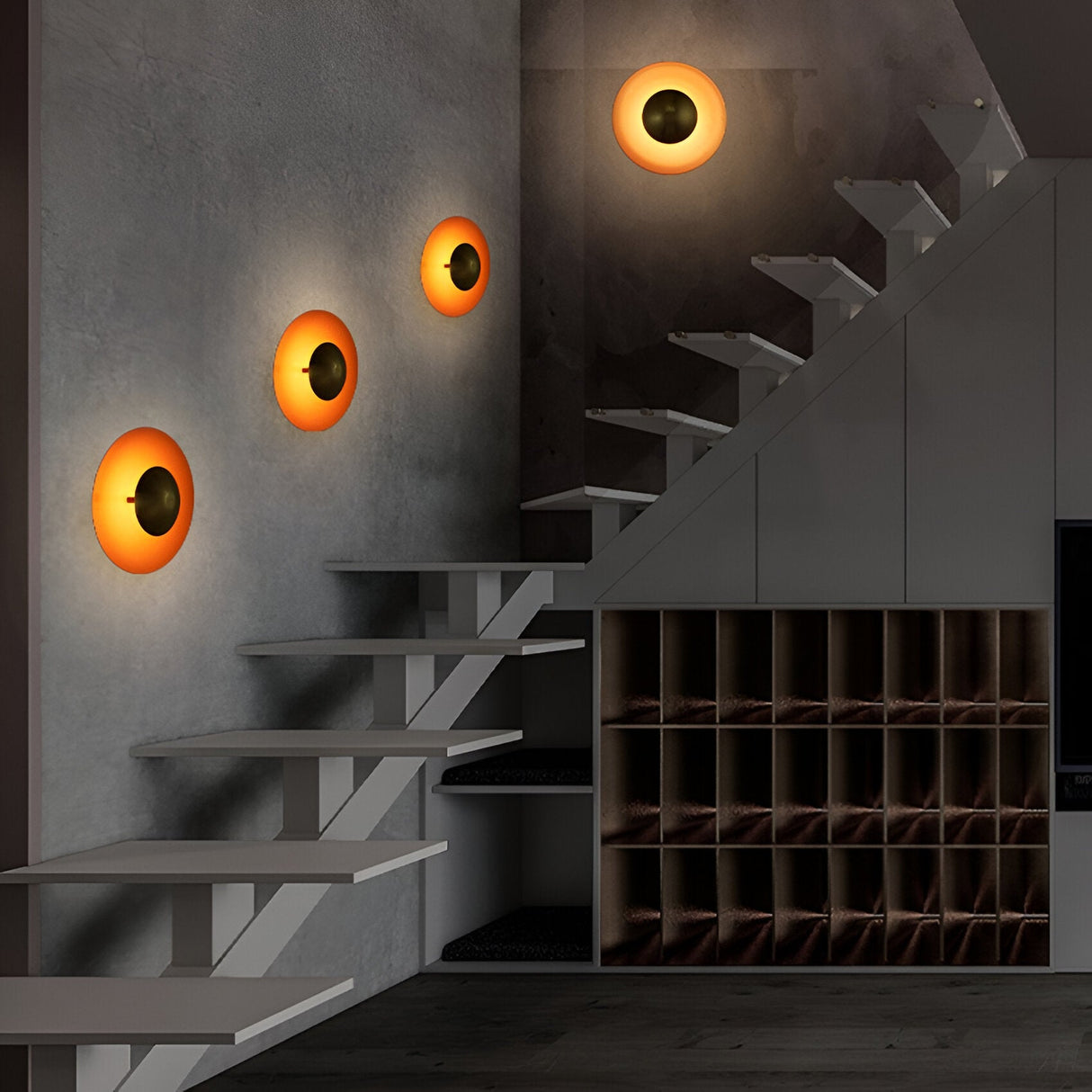 Four orange disc sconces lit along a wall beside a staircase