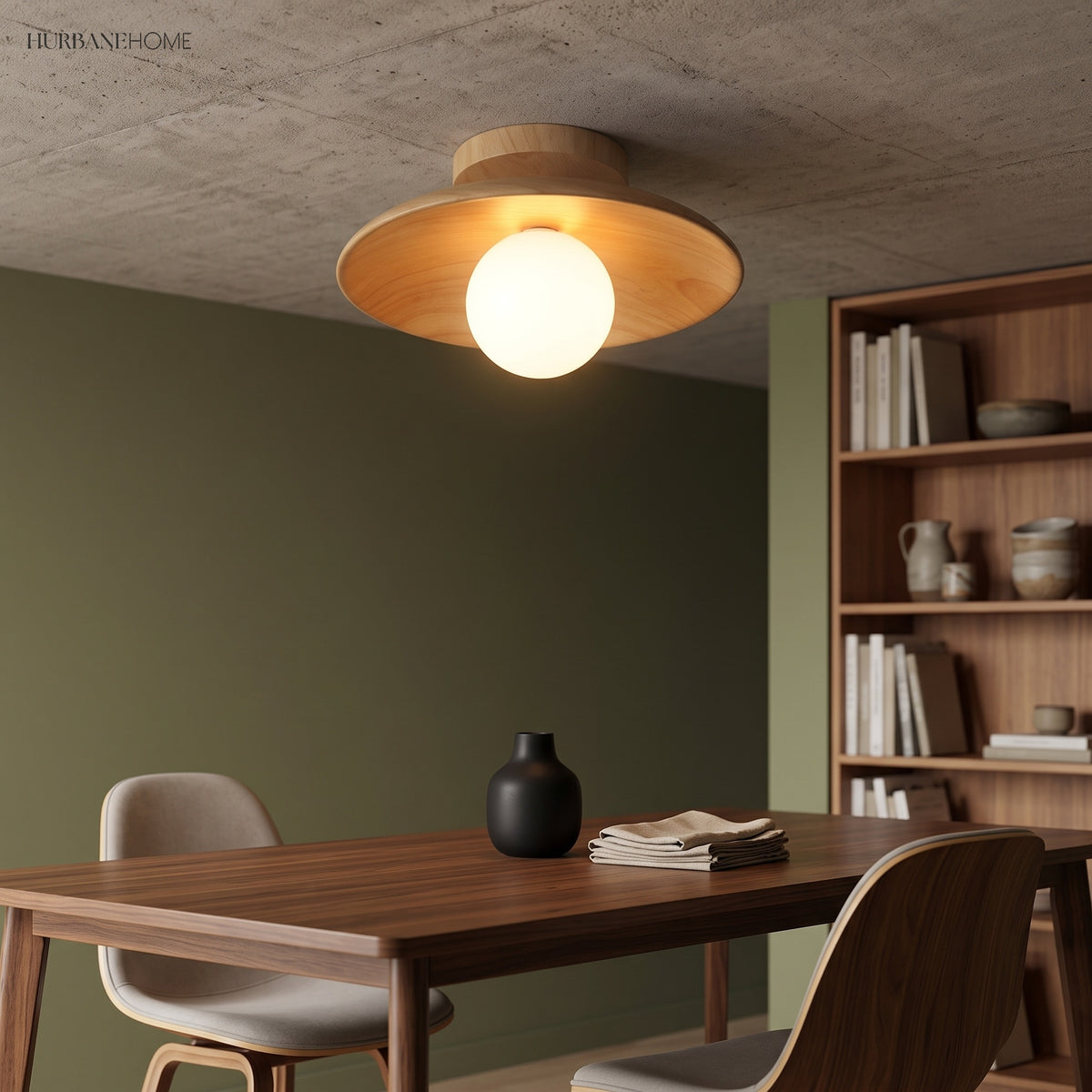 Wood ceiling light lit above a dining table on a green wall