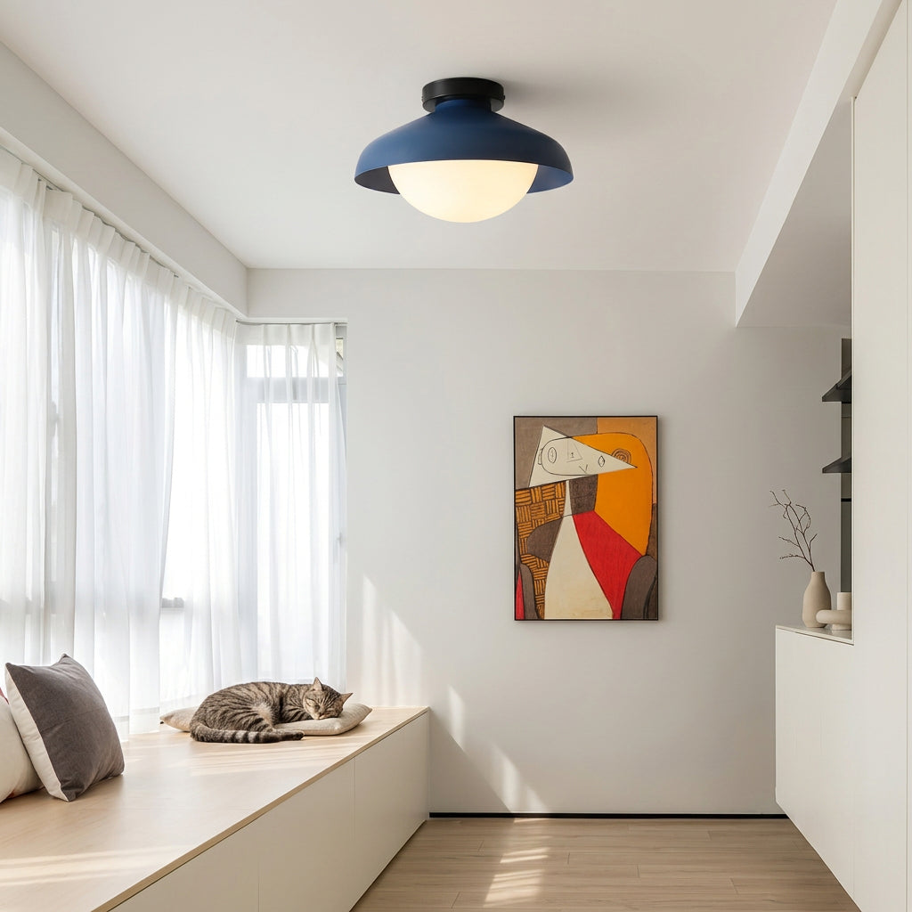 Blue dome ceiling light in a bright room above a window bench and framed print