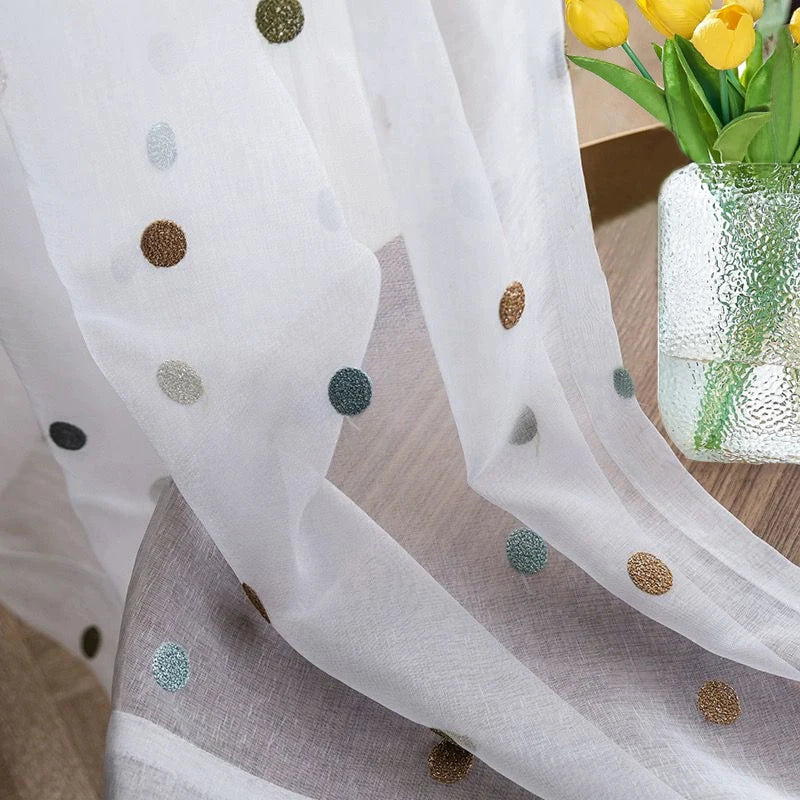 Sheer voile window curtain panels draped in modern apartment living space