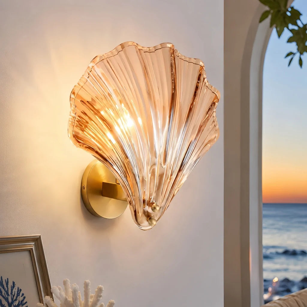 Transparent glass shell wall sconce shown on a plain studio background