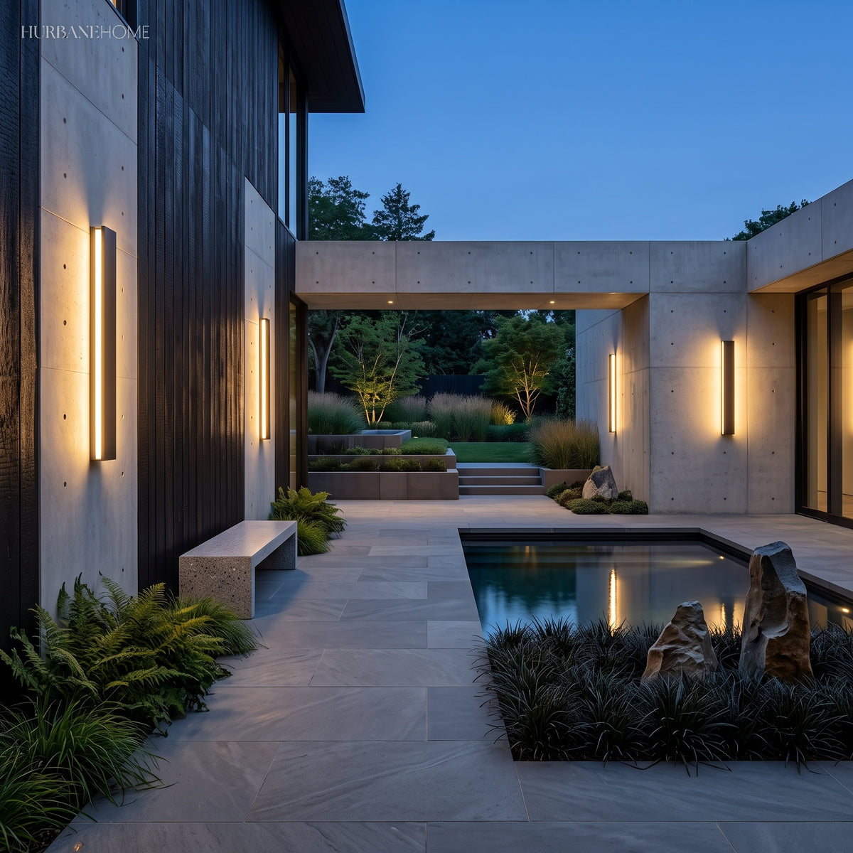 Linear lights on a black clad wall beside a lit pool at dusk