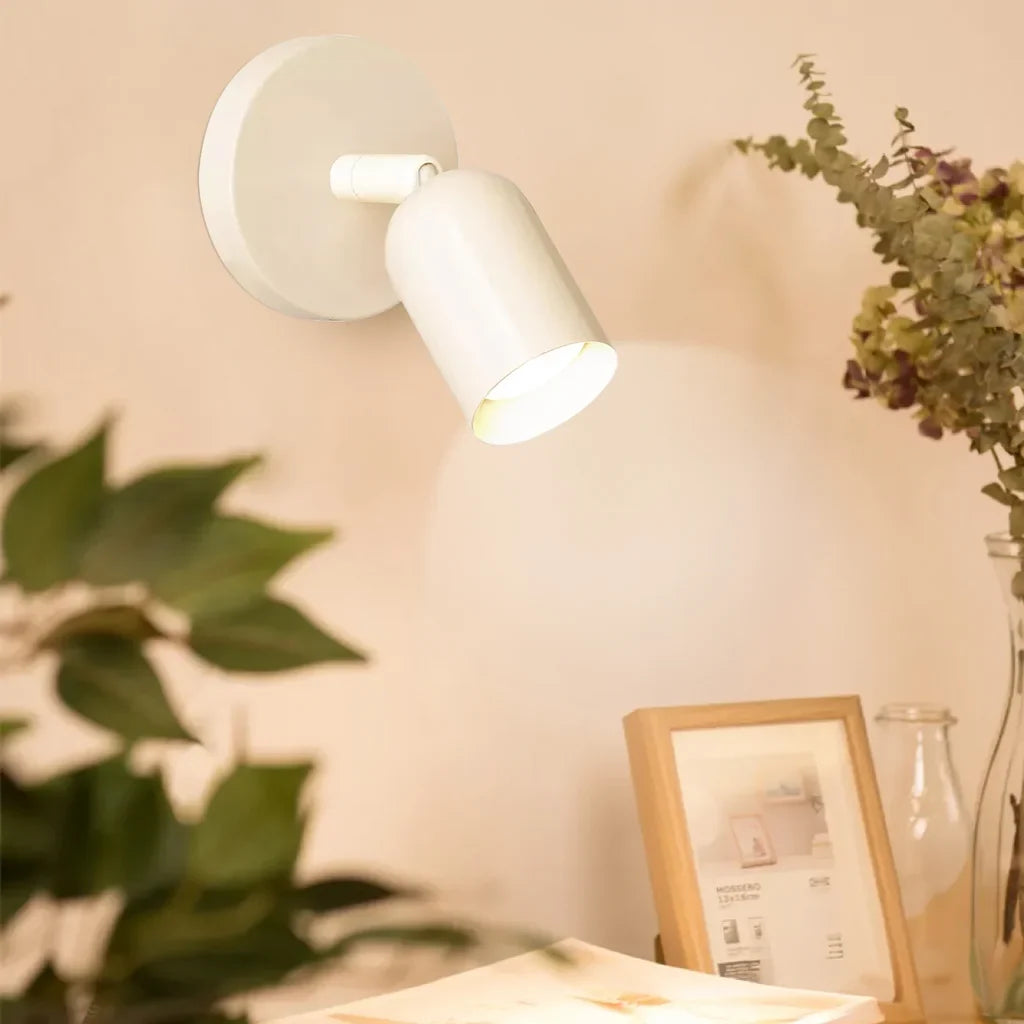 Solid colour bedside wall sconce shown from the front with lit shade