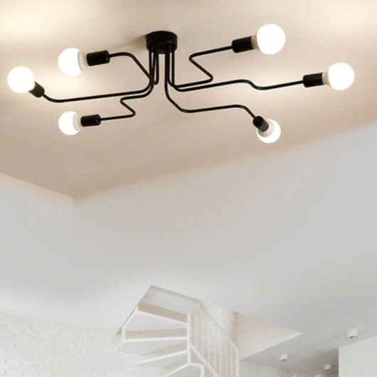 Black sputnik chandelier lit on a white ceiling above a stairwell