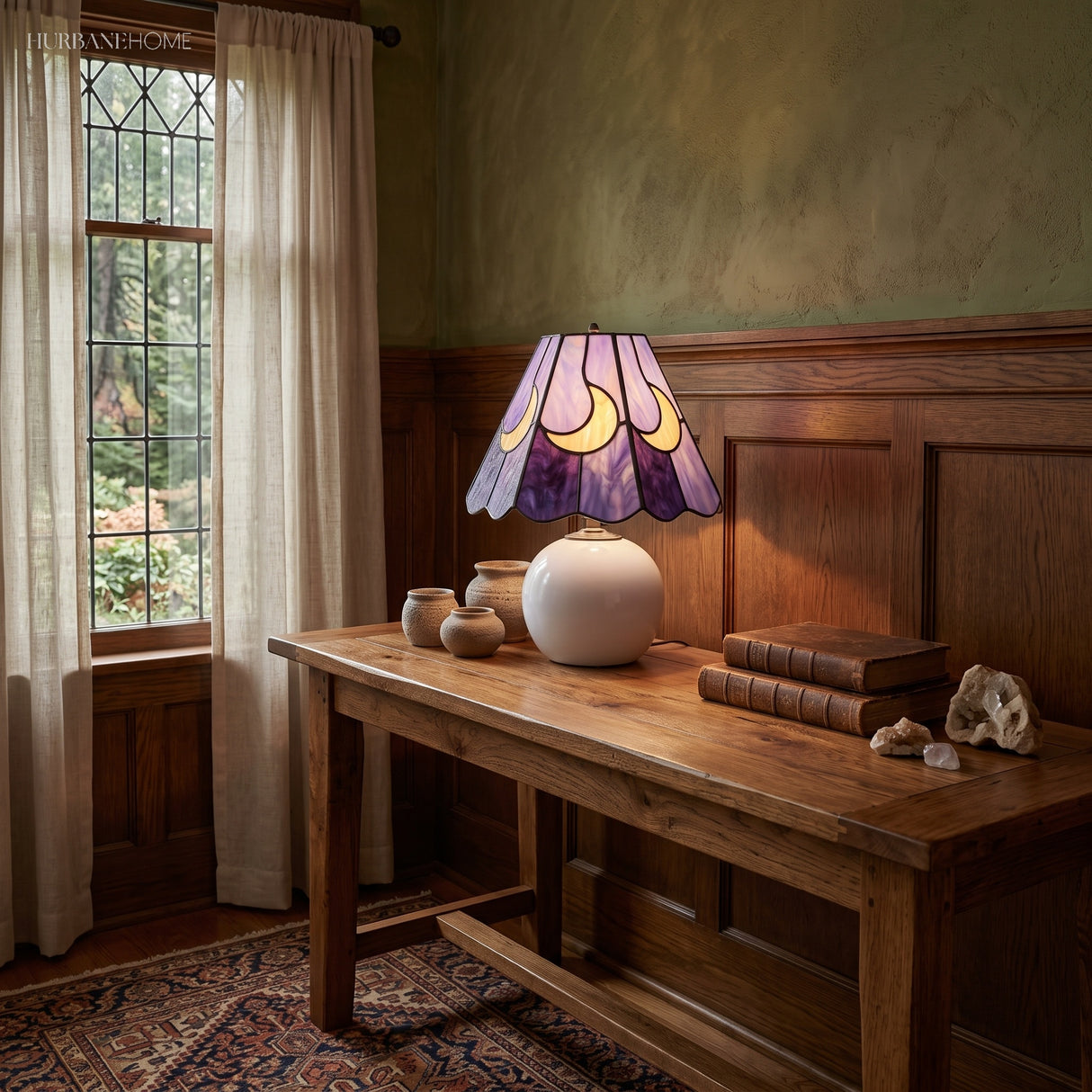 Leaded glass lamp lighting a dark panelled dining room with stacked books