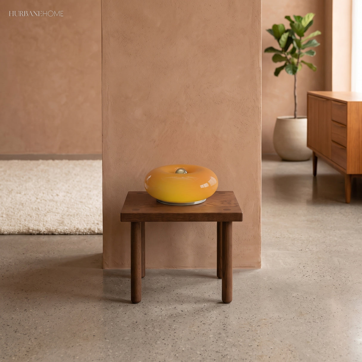 Amber donut glass lamp on a wooden stool