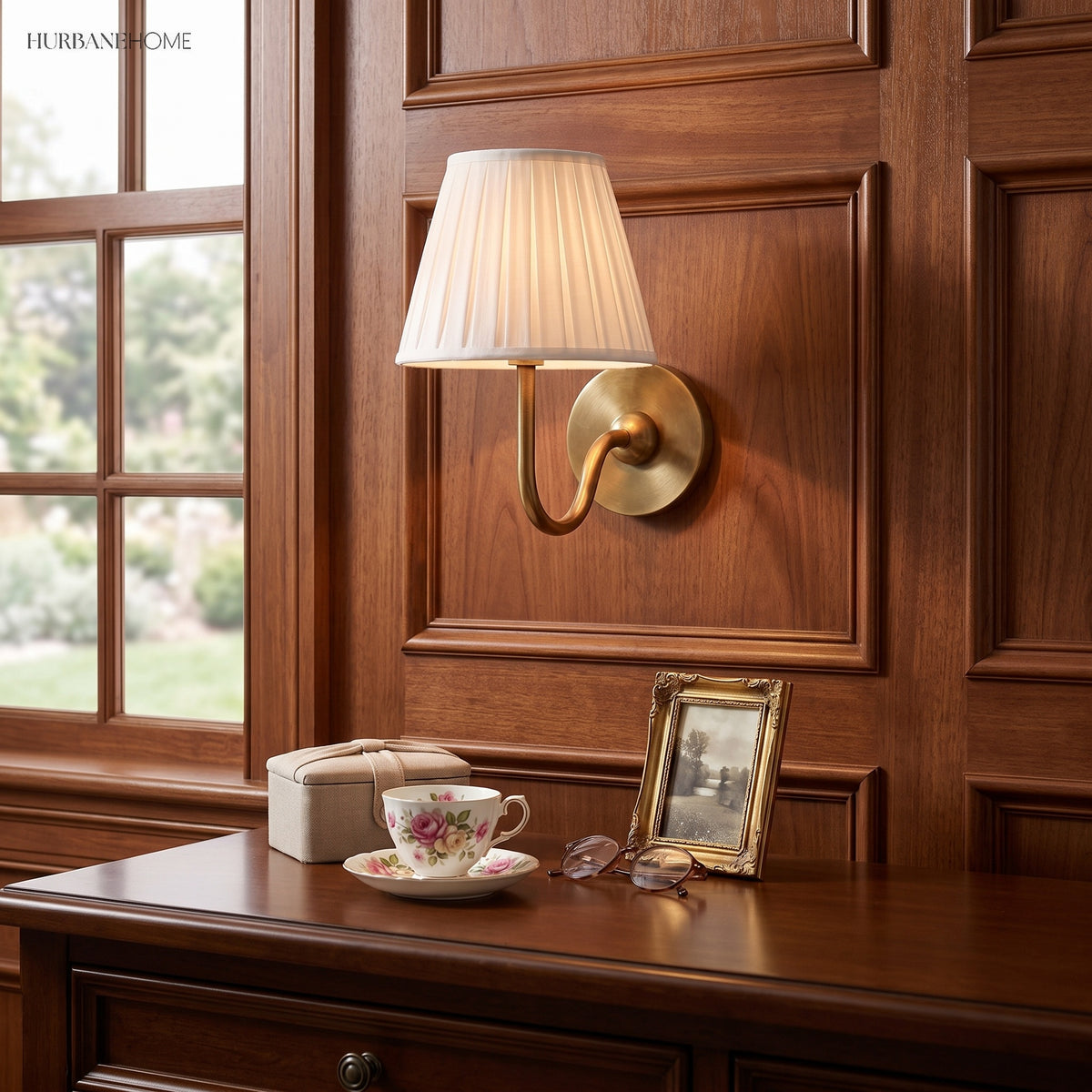 Warm brass pleated linen sconce on walnut panelling above a desk