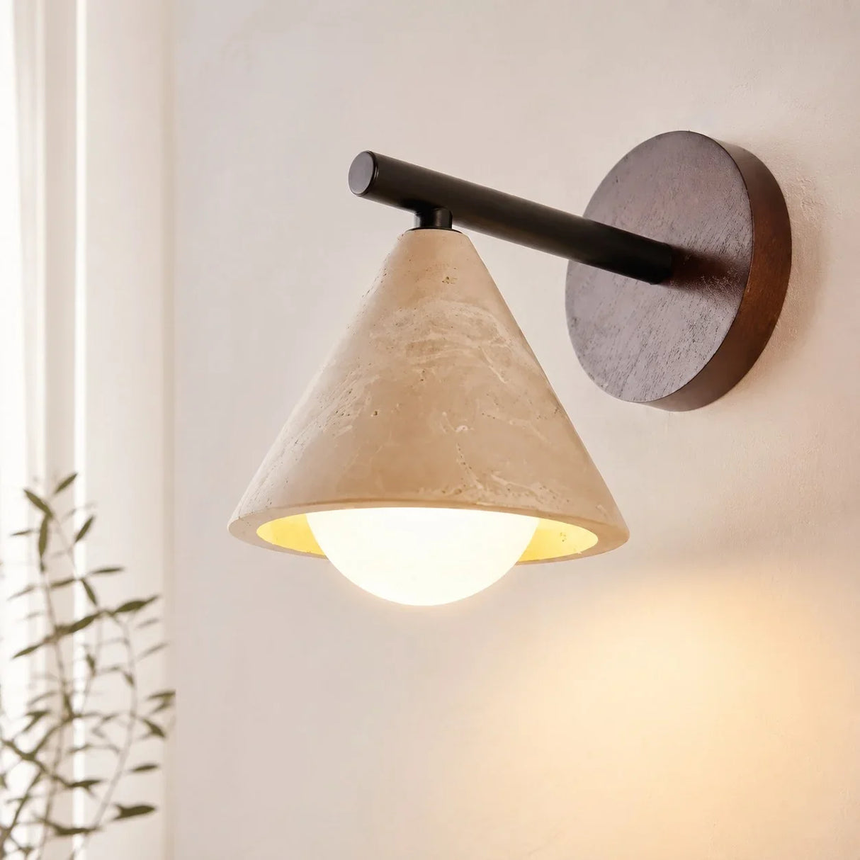 Close view of travertine stone shade, black arm and round wood backplate