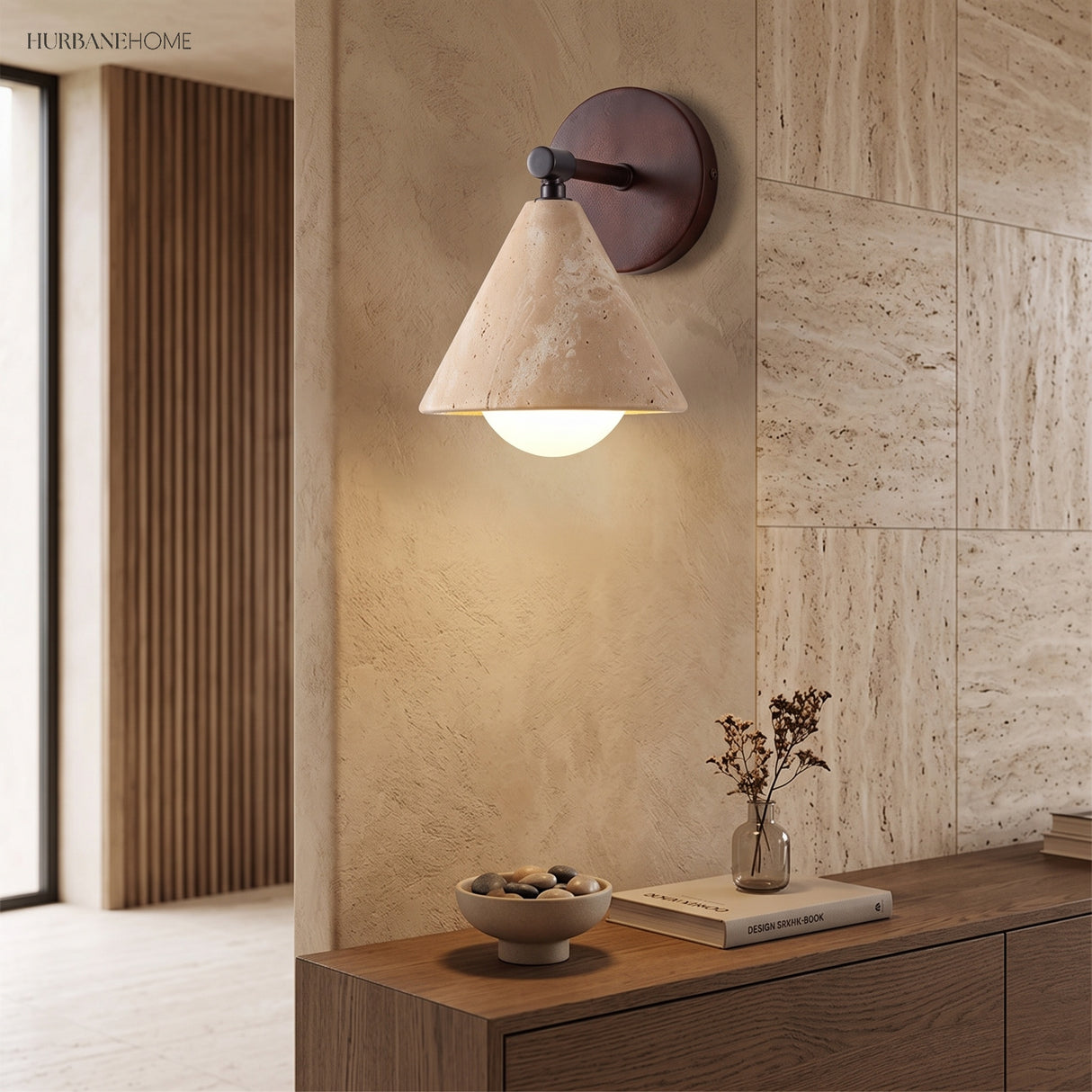 Modern wall sconce lighting a travertine tile wall in a hallway