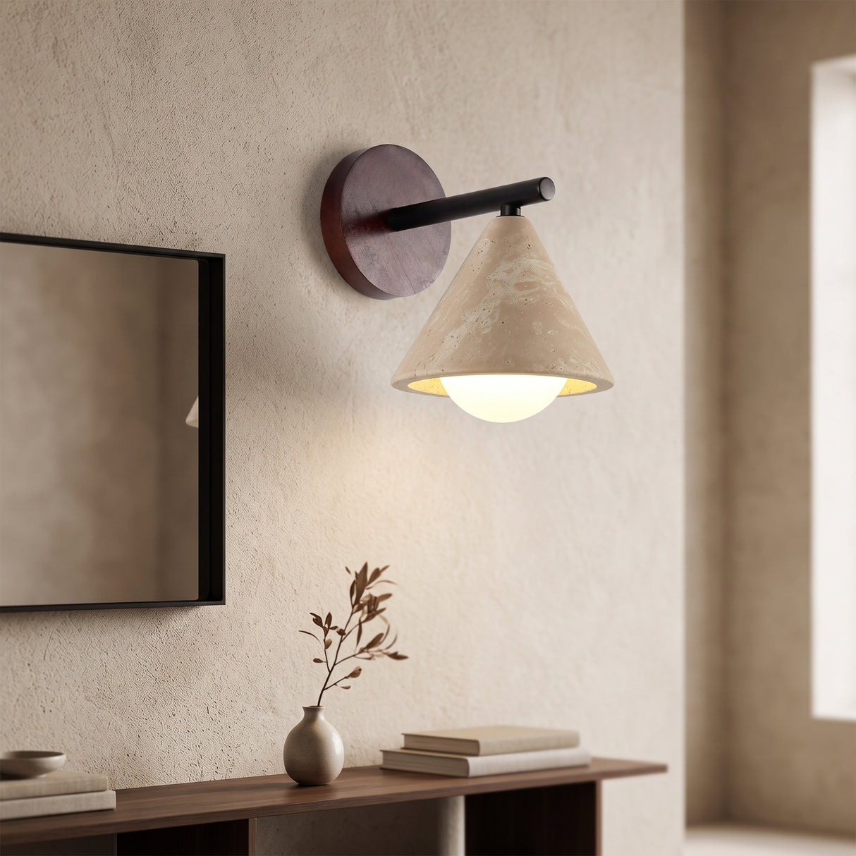 Travertine cone wall sconce with walnut backplate beside a mirror