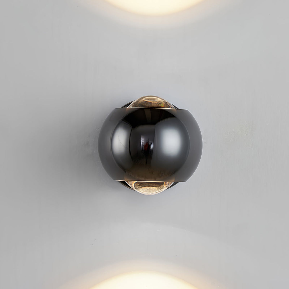 Black orb sconce lit on a plain white wall with beams above and below