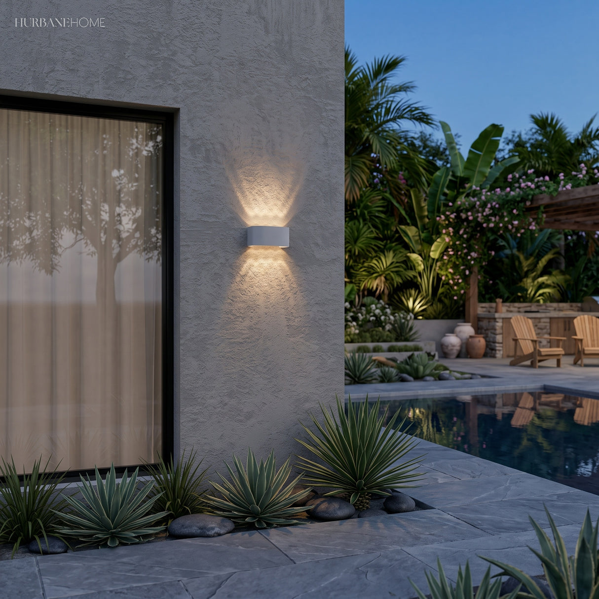 White up and down light on a render wall beside a pool and planting at dusk