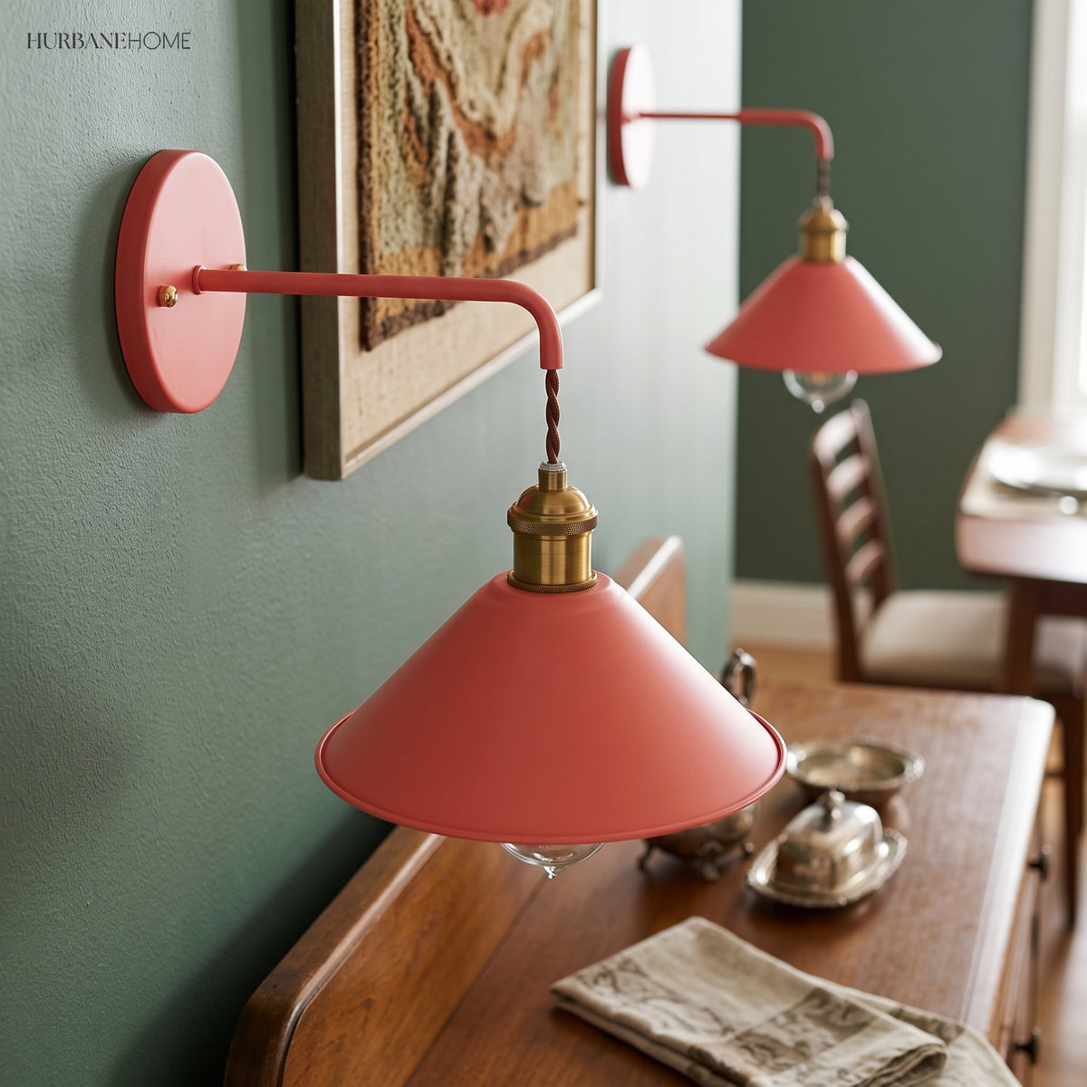 Two coral cone shade sconces lit above a writing desk