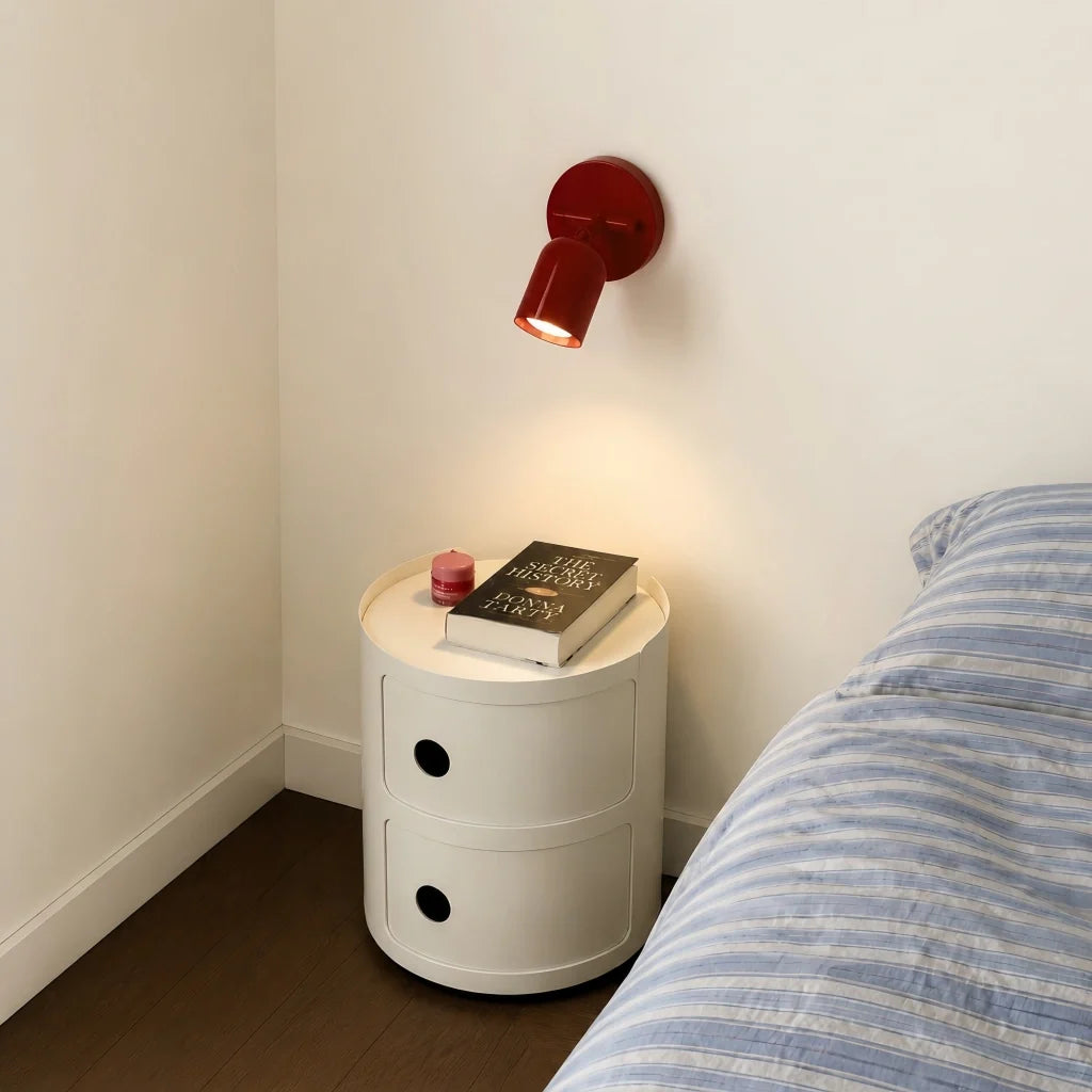 Close view of the round wall backplate and push-button switch on the sconce