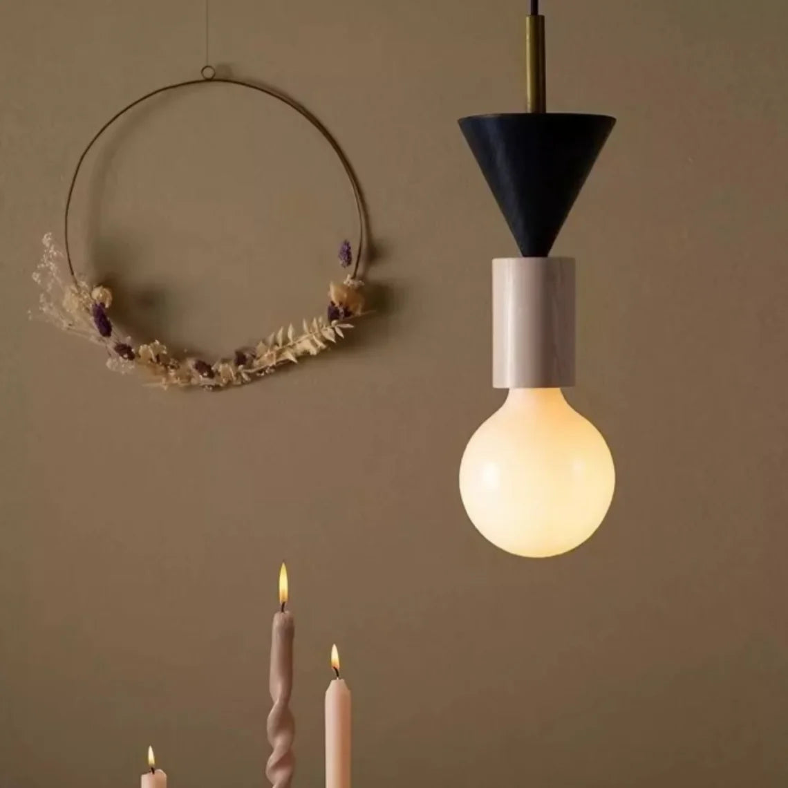 Contemporary geometric pendant light hanging near a soft neutral backdrop