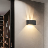 Black modern wall sconce lighting a hallway near a wardrobe