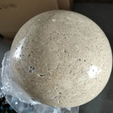 Close-up of the lit travertine stone disc with its soft warm halo