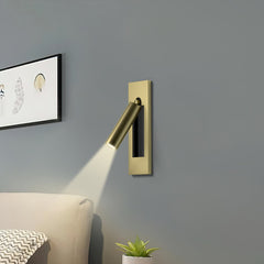 Warm reading light glow beside pillows and a headboard at night