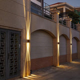 Row of wall lights washing beige pillars above garage doors at dusk