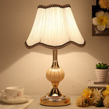 Gold base glass table lamp with plain scalloped cream shade