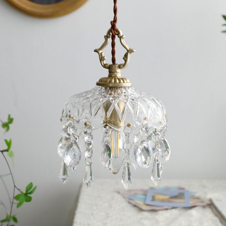Unlit pendant light close-up with gold hardware and a gold wall frame