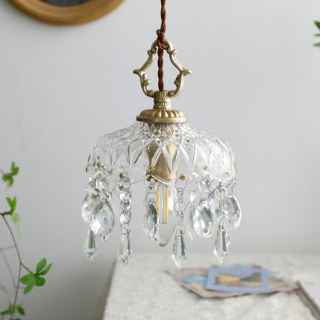 Unlit pendant light close-up with gold hardware and a gold wall frame