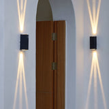Pair of wall lights beside an arched doorway with twin beams on white plaster