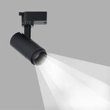 Black tubular spotlight head with graduated tilt dial casting a beam