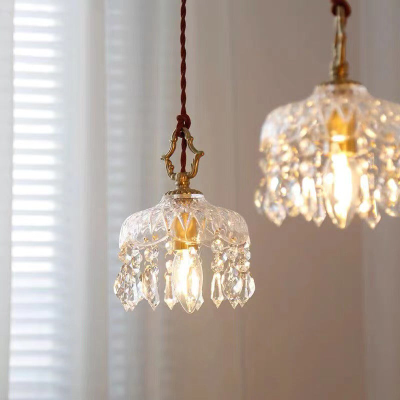 Glowing pendant light with a gold cap over a table with round wall frame