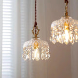 Glowing pendant light with a gold cap over a table with round wall frame