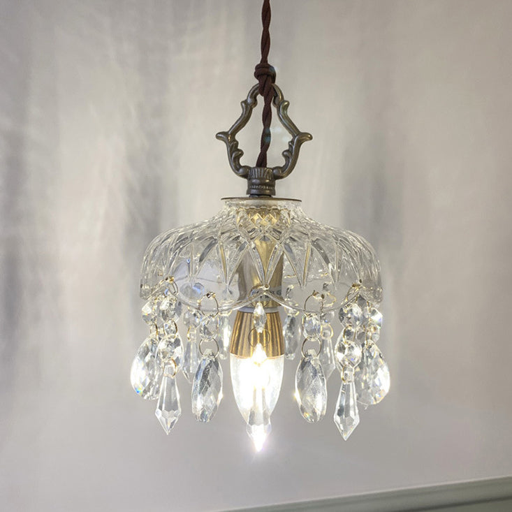Vintage pendant light with copper hardware glowing against a grey wall