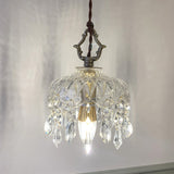 Vintage pendant light with copper hardware glowing against a grey wall