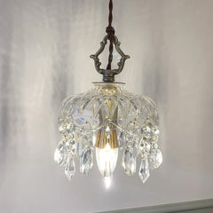 Vintage pendant light with copper hardware glowing against a grey wall
