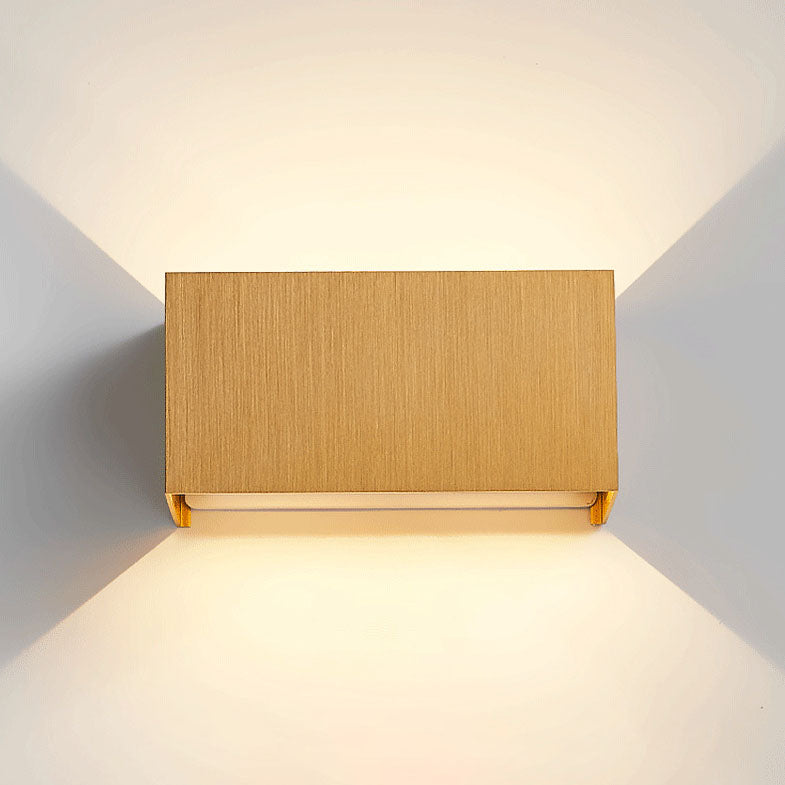 Coffee gold up and down wall sconce mounted on a neutral wall