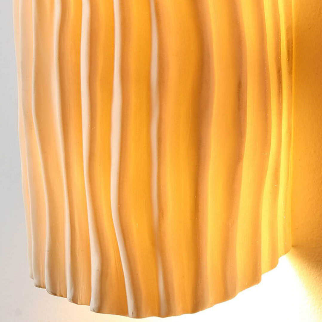 Close-up of the creamy yellow rippled resin texture on the sconce shade