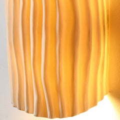 Close-up of the creamy yellow rippled resin texture on the sconce shade